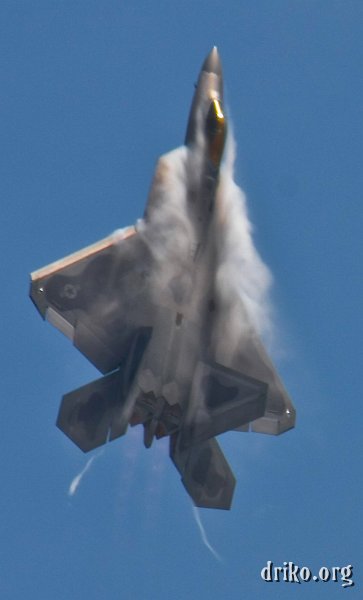 IMG_4768_800.jpg - As the F-22 pulls hard vertically, vapor over the leading edge of the wing and engine intake condenses.  Note the shock cones produced by full afterburner...