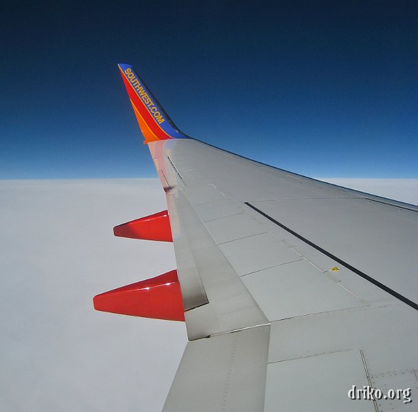 IMG_2387_800.jpg - The nice lines of the 737-700 wing against a beautiful blue sky and a pristine cloud layer.